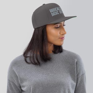 Radicalized by Basic Decency snapback hat for progressives, embroidered political flat brim cap for voters, gift for activists and students Dark Grey