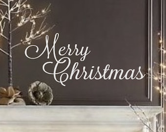 以下が含まれることがあります： 白い壁用デカールで、筆記体でMerry Christmasと書かれたテキストが、四角いプランターに入った小さな温かみのある白色LEDライトで照らされた複数の人工の枝木で飾られた暖炉のマントルピースの上に飾られています。