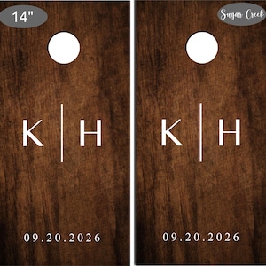 Op de afbeelding: Twee houten cornhole-borden met een donkerbruine afwerking. Elk bord heeft een witte cirkel, de initialen "K|H" en de datum "09.20.2026". De borden hebben een diameter van 35,5 cm en zijn van Sugar Creek.