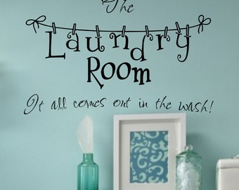 Peut inclure: Une pancarte de buanderie noire et blanche avec le texte "The Laundry Room" et une corde à linge avec des pinces à linge accrochées. Le texte sous la pancarte dit "It all comes out in the wash!"