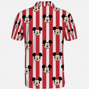 Puede incluir: Camisa de manga corta con un estampado repetido de caras de Mickey Mouse sobre un fondo a rayas rojas y blancas. La camisa tiene un cuello cl&aacute;sico y est&aacute; hecha de una tela ligera, perfecta para ropa casual.