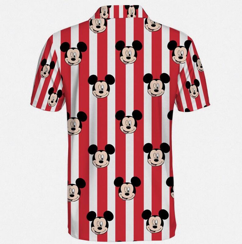 Puede incluir: Camisa de manga corta con un estampado repetido de caras de Mickey Mouse sobre un fondo a rayas rojas y blancas. La camisa tiene un cuello cl&aacute;sico y est&aacute; hecha de una tela ligera, perfecta para ropa casual.