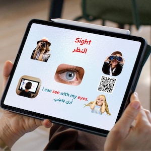 以下が含まれることがあります： タブレットには、英語とアラビア語で「Sight」という単語が表示され、目、双眼鏡を使用している人、写真を撮っている人のイラストが描かれています。「I can see with my eyes」というテキストも表示されています。