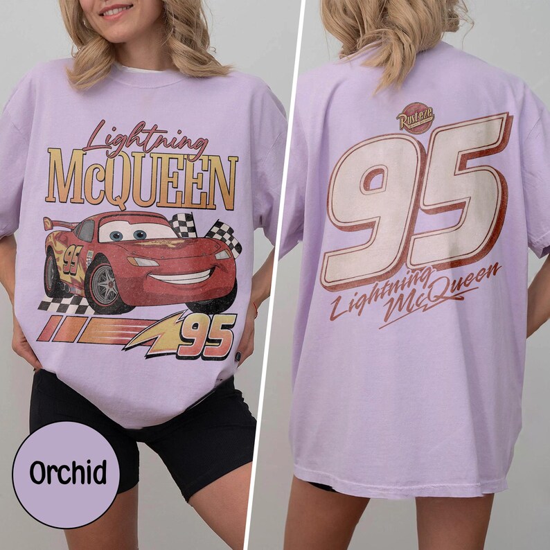 May include: Orchid-colored t-shirt featuring Lightning McQueen from the Cars movie. The front graphic shows the car, the number 95, and the text "Lightning McQueen". The back of the shirt has a large "95" and "Lightning McQueen" text.