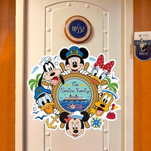 May include: A colorful door decoration featuring Disney characters Mickey Mouse, Minnie Mouse, Goofy, Donald Duck, Daisy Duck, and Pluto. The design includes a ship's wheel with the text "The Smith Family 2020" and a cruise ship illustration.