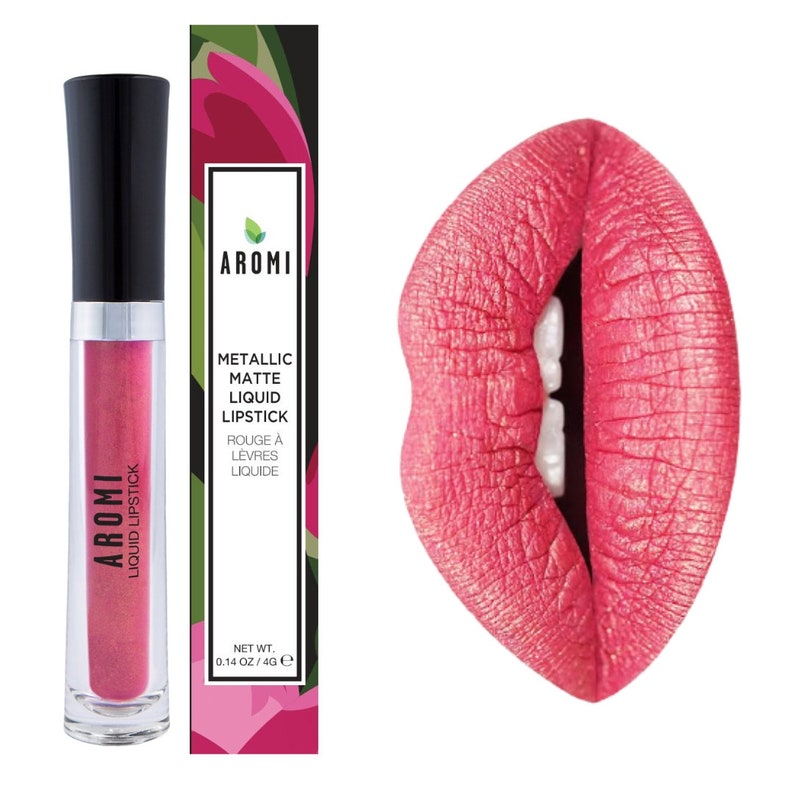 K&ouml;nnte beinhalten: Ein transparentes R&ouml;hrchen mit schwarzem Deckel, das einen rosa metallischen fl&uuml;ssigen Lippenstift enth&auml;lt. Das R&ouml;hrchen ist mit "AROMI LIQUID LIPSTICK" beschriftet. Das Produkt ist in einer Schachtel mit floralem Design und dem Text "AROMI METALLIC MATTE LIQUID LIPSTICK ROUGE &Agrave; LEVRES LIQUIDE NET WT. 0.14 OZ/4G e" verpackt.