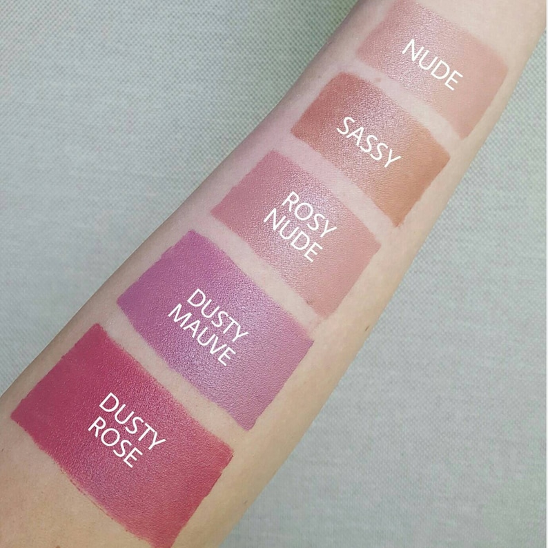 K&ouml;nnte beinhalten: F&uuml;nf verschiedene Lippenstift-Farbtupfer auf dem Arm einer Person. Die Farbt&ouml;ne sind mit "Dusty Rose", "Dusty Mauve", "Rosy Nude", "Sassy" und "Nude" beschriftet.
