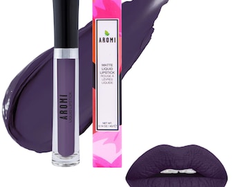 May include: A tube of Aromi matte liquid lipstick in a deep purple shade, accompanied by its rectangular box featuring a vibrant pink and red floral pattern. The packaging displays the brand name Aromi and the net weight of 0.14 oz / 4g.
