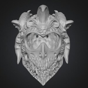 Puede incluir: Una m&aacute;scara detallada, impresa en 3D en escala de grises, con un pico de p&aacute;jaro y rasgos de calavera. La m&aacute;scara tiene cuernos, protuberancias en forma de oreja y una superficie texturizada, lo que sugiere un tema de fantas&iacute;a o g&oacute;tico.