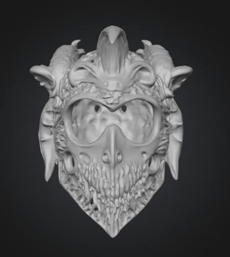 Puede incluir: Una m&aacute;scara detallada, impresa en 3D en escala de grises, con un pico de p&aacute;jaro y rasgos de calavera. La m&aacute;scara tiene cuernos, protuberancias en forma de oreja y una superficie texturizada, lo que sugiere un tema de fantas&iacute;a o g&oacute;tico.