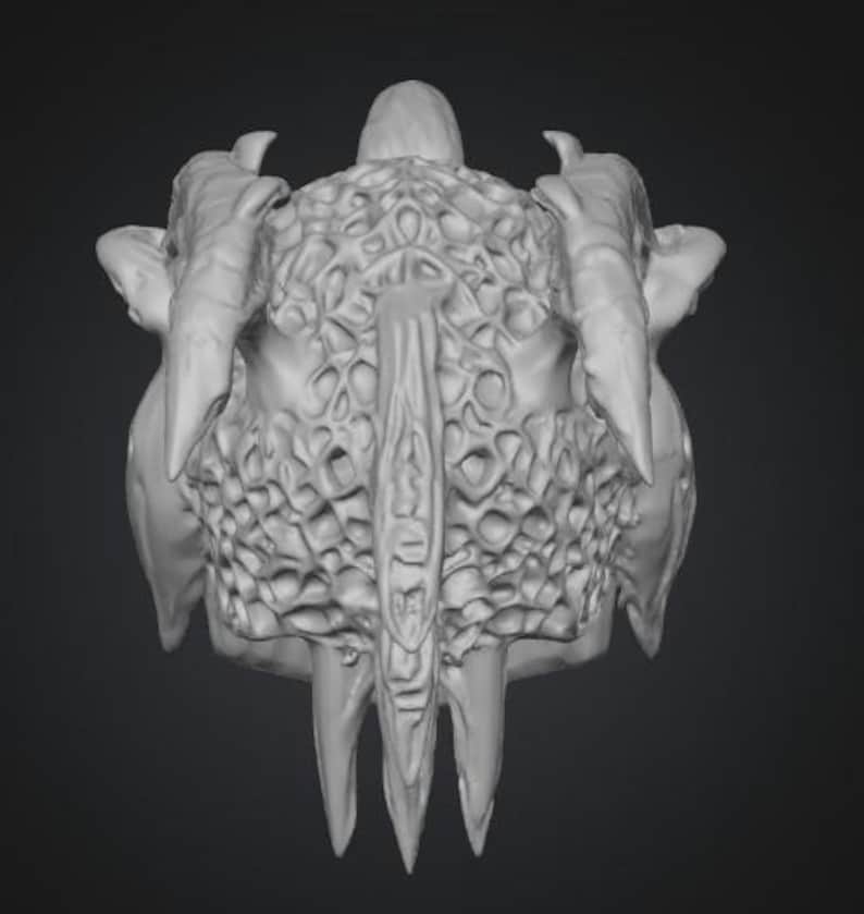 Puede incluir: Representaci&oacute;n en escala de grises de una calavera de criatura tridimensional. La calavera presenta cuernos grandes y curvos, una superficie texturizada y dientes afilados y puntiagudos. El dise&ntilde;o tiene una apariencia org&aacute;nica detallada, que sugiere un tema de fantas&iacute;a u horror.
