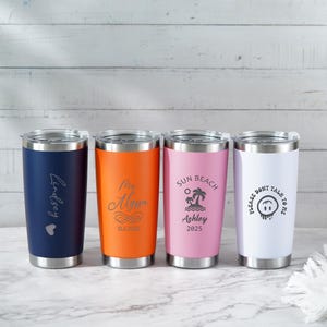 May include: Four stainless steel tumblers in navy, orange, pink, and white. Each tumbler has a silver lid and base. The navy tumbler has the name "Lindsey" and a heart. The orange tumbler has the name "My Alyssa" and the date 13.6.2025. The pink tumbler has the words "Sun Beach Ashley 2025". The white tumbler has the words "Please Don't Talk To Me" and a smiley face.