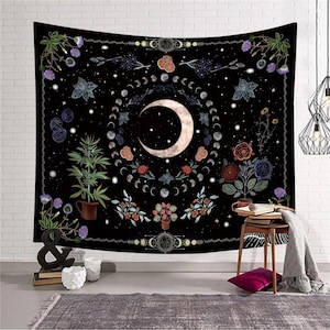 May include: Black tapestry featuring a crescent moon surrounded by phases of the moon and floral elements. The design includes stars, flowers, and botanical illustrations. The tapestry is a decorative wall hanging.