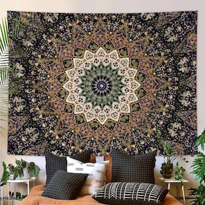 May include: A large tapestry with a detailed mandala design. The tapestry features a central starburst pattern in shades of green, purple, and gold against a black background. The design is symmetrical and intricate, suitable for wall decor.