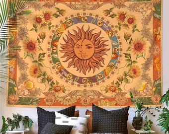 May include: A large, rectangular tapestry with a celestial design. The tapestry features a central sun and moon face, surrounded by zodiac symbols and sunflowers. The color palette includes shades of orange, yellow, green, and brown, creating a warm and inviting aesthetic.