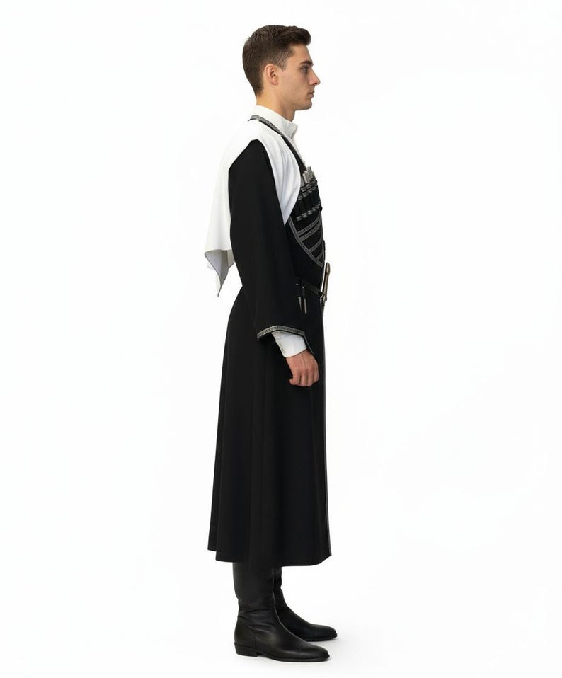 May include: A person in a traditional black and white outfit, viewed from the side. The outfit features a long black coat, a white shirt, and a white shawl. The coat has silver trim, and the person is wearing black boots.