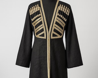 May include: A black coat with gold embroidery. The coat has gold trim and decorative gold embellishments on the shoulders and chest. The long sleeves and knee-length design create a formal look.