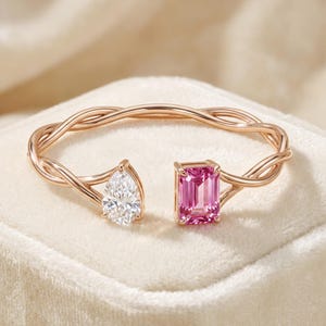 Puede incluir: Pulsera de oro rosa con una gema blanca en forma de pera y una gema rosa rectangular. La pulsera tiene un diseño retorcido. Las gemas están en los extremos opuestos de la pulsera abierta.