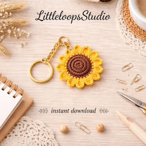 Puede incluir: Un llavero de girasol tejido a ganchillo con una cadena y un anillo dorados. El girasol tiene un anillo exterior amarillo y un centro marrón. La imagen también incluye el texto "LittleloopsStudio" y "instant download".