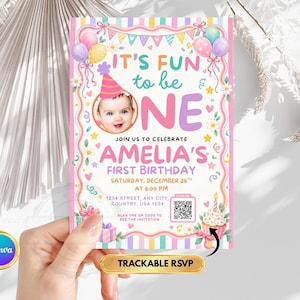 Peut inclure: Une carte d'invitation pour un premier anniversaire avec la photo d'un bébé portant un chapeau de fête, des ballons colorés, des guirlandes et un cupcake. Le texte indique IT'S FUN to be ONE, AMELIA'S FIRST BIRTHDAY, date, heure, adresse et QR code.