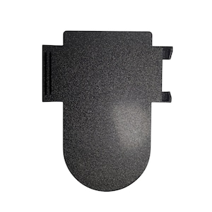 May include: A textured, black metal object with a distinctive shape. It has a rectangular top with two small projections and a rounded base. The surface has a speckled appearance, suggesting a matte finish. The object's design is modern and minimalist.