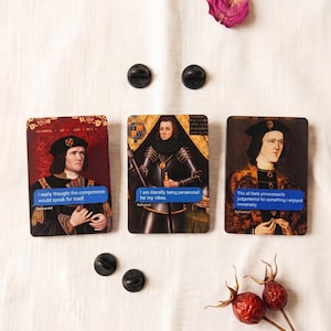 May include: Three cards featuring portraits of historical figures with speech bubbles containing modern phrases. Two black pin badges are also visible. The speech bubbles say: "I really thought the competence would speak for itself", "I am literally being persecuted for my vibes", and "This all feels unnecessarily judgemental."