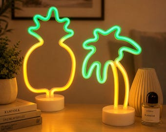 Può includere: Due lampade al neon con forme tropicali. Una lampada ha la forma di un ananas con la parte superiore verde e la base gialla, mentre l'altra è una palma con foglie verdi e tronco giallo. Entrambe le lampade poggiano su basi circolari bianche.