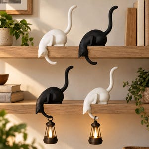 May include: Four cat-shaped figurines are positioned on wooden shelves. Two are solid white and two are solid black. Each cat has an arched tail. Two of the cats are holding small, dark-colored lanterns with glowing lights hanging from their paws.