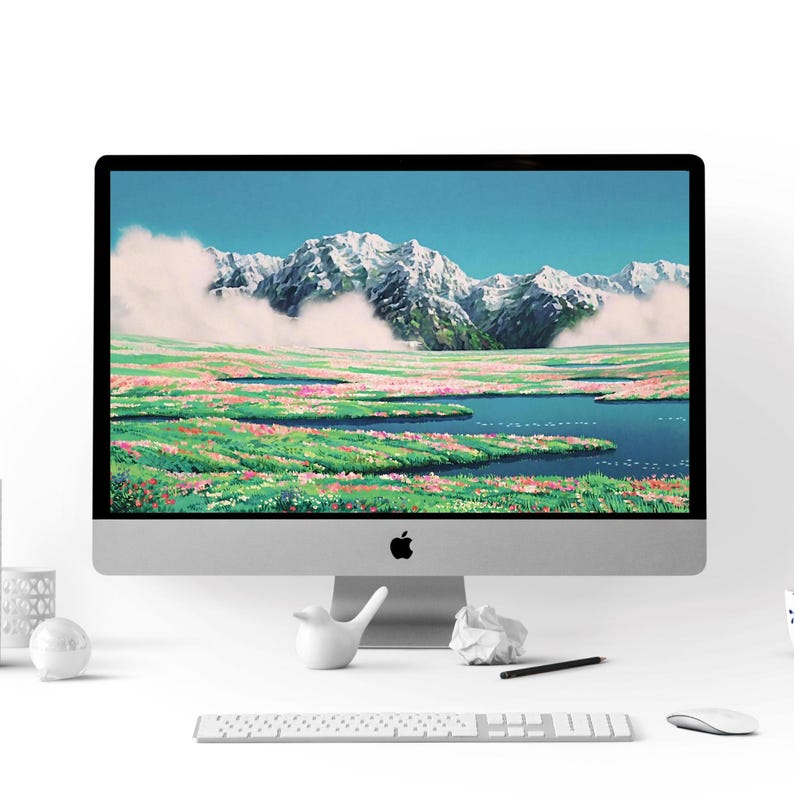 K&ouml;nnte beinhalten: Ein moderner Desktop-Computer mit wei&szlig;em Hintergrund und einem Landschaftsbild auf dem Bildschirm. Das Bild zeigt ein Feld mit Blumen und einer Bergkette im Hintergrund.