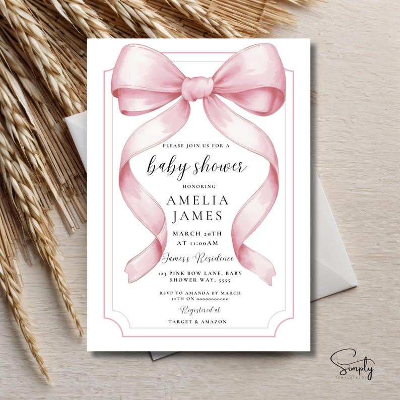 May include: Pink baby shower invitation with a watercolor bow and the text "Please join us for a baby shower honoring Amelia James March 20th at 11:00 AM Jamess Residence 121 Pink Bow Lane, Baby Shower Way, 5555 RSVP to Amanda by March (TIE ON) Registered at TARGET & AMAZON"