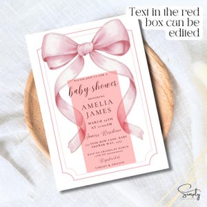 May include: A pink baby shower invitation with a large pink bow and the text "Please join us for a baby shower honoring Amelia James March 20th at 11:00 AM Jamess Residence 123 Pink Bow Lane, Baby Shower Way, 5555 RSVP to Amanda by March 13th on Registered at Target & Amazon"