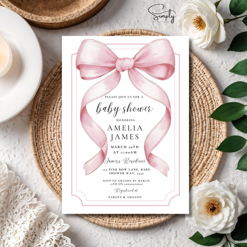 May include: A pink baby shower invitation with a watercolor bow and the text "Please join us for a baby shower honoring Amelia James March 20th at 11:00 AM Jamess Residence 123 Pink Bow Lane, Baby Shower Way, 5555 RSVP to Amanda by March 14th on 0000000000 Registered at Target & Amazon"
