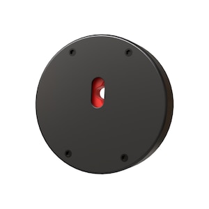 May include: A black, circular object with a red, keyhole-shaped opening in the center. Four small, dark screws are evenly spaced around the perimeter. The object appears to be made of metal or a similar material.