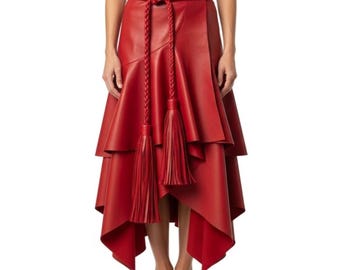 Può includere: Gonna in pelle rossa con design a strati e orlo asimmetrico. La gonna presenta una cintura intrecciata con due lunghe nappe. La gonna è lunga fino al ginocchio e ha una silhouette fluida ed elegante.