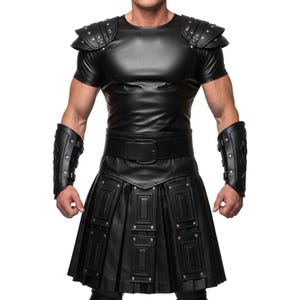 May include: Black leather costume featuring a short-sleeved top with studded shoulder pads, a wide belt, and a pleated skirt with rectangular accents. The costume includes matching arm cuffs. The outfit is designed for a theatrical or cosplay look.