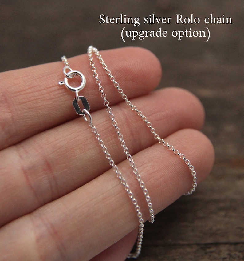 May include: Sterling silver rolo chain, an upgrade option for jewellery. The chain is silver and has a lobster clasp.