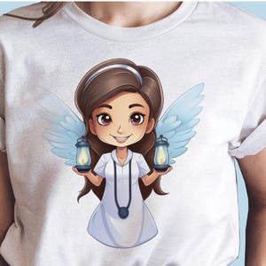 May include: White t-shirt featuring a cartoon illustration of a girl angel with brown hair and blue wings holding two lanterns. The girl is wearing a white dress and a necklace with a pendant.
