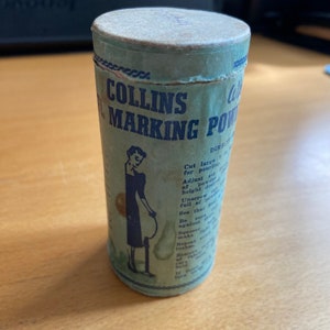 Puede incluir: Un recipiente de cartón vintage verde y blanco de polvo de marcado Collins. El recipiente tiene una etiqueta azul con instrucciones de uso y una ilustración en blanco y negro de una mujer usando el polvo.