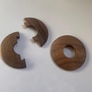 以下が含まれることがあります： パズルの木製ピース3つ。2つは真ん中に切り抜きのある半円形、もう1つは真ん中に切り抜きのある円形です。