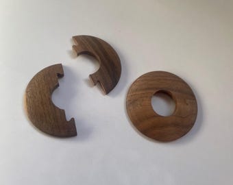Könnte beinhalten: Drei Holzteile eines Puzzles, zwei sind Halbkreise mit einem Ausschnitt in der Mitte, und das dritte ist ein Vollkreis mit einem Ausschnitt in der Mitte.