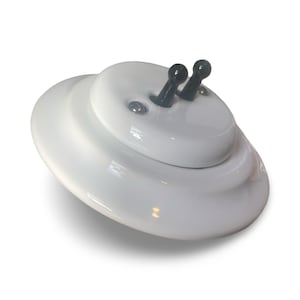May include: A white ceramic light switch with two black toggle switches. The switch has a layered design and a glossy finish. The product is designed for electrical use and is likely for home decor.