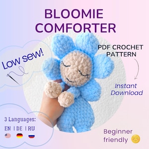 Könnte beinhalten: Eine gehäkelte, blau-beige blütenförmige Decke. Das Bild enthält den Text "BLOOMIE COMFORTER", "PDF CROCHET PATTERN", "Instant Download", "Low sew!" und "Beginner friendly". Die Decke wird von einer Hand gehalten.