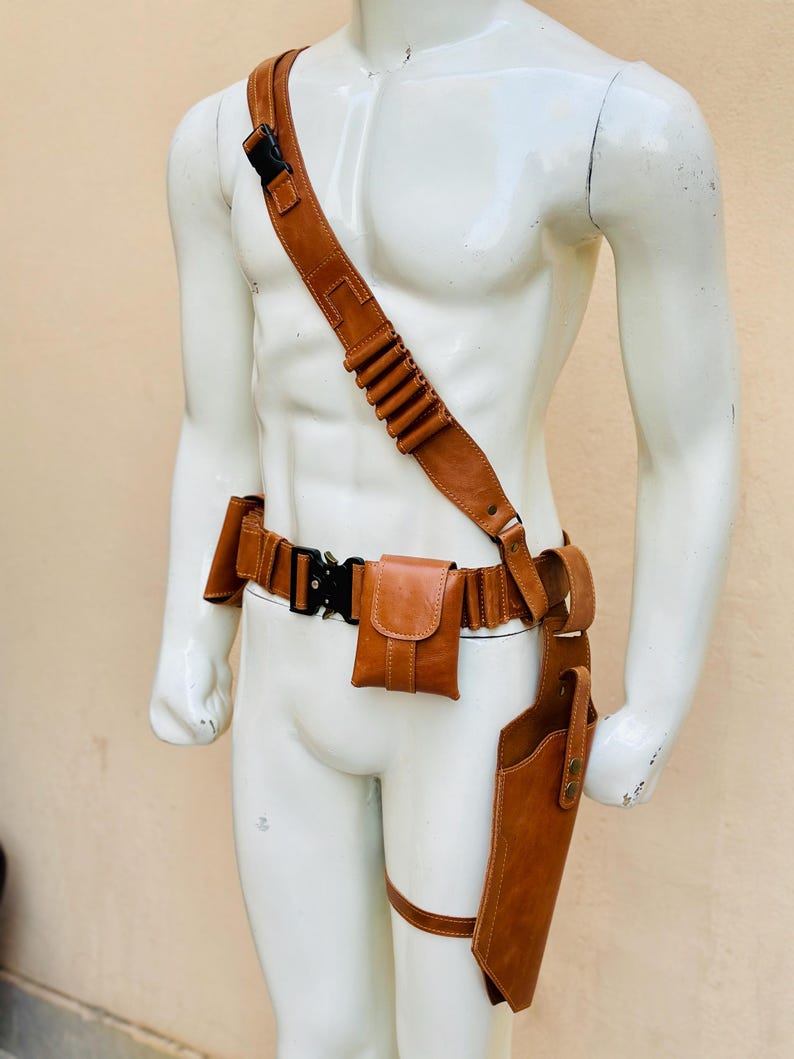 Peut inclure: Ensemble de ceinture et d'&eacute;tui utilitaire en cuir marron. L'ensemble comprend une bandouli&egrave;re avec des boucles pour cartouches, une ceinture avec une pochette et une sangle de jambe avec un &eacute;tui. Le cuir est de couleur marron moyen avec des coutures visibles et du mat&eacute;riel m&eacute;tallique.