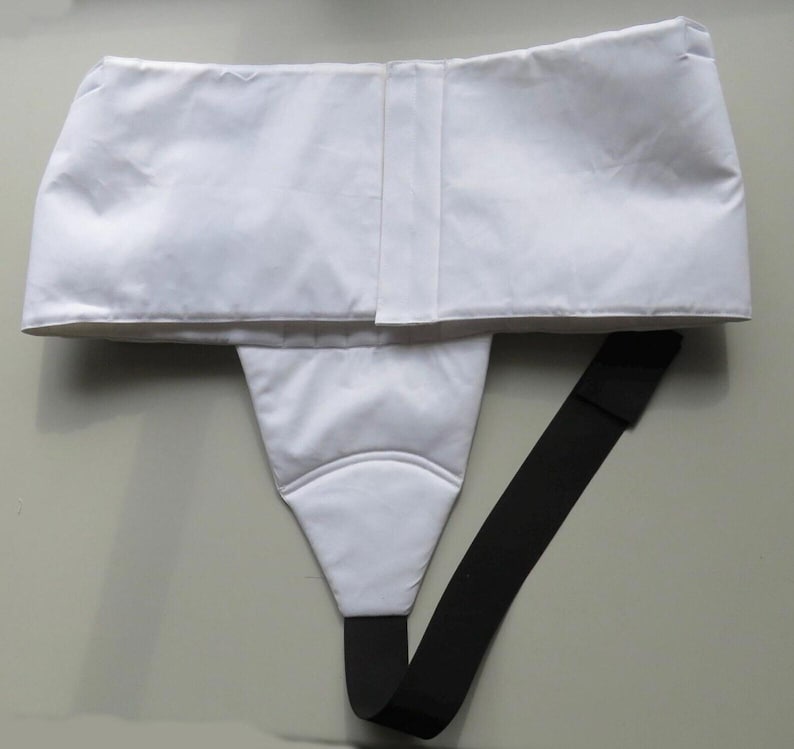 Puede incluir: Un suspensorio atl&eacute;tico blanco con una cintura ancha y una bolsa triangular. Una correa el&aacute;stica negra se extiende desde la bolsa. Dise&ntilde;ado para uso atl&eacute;tico.