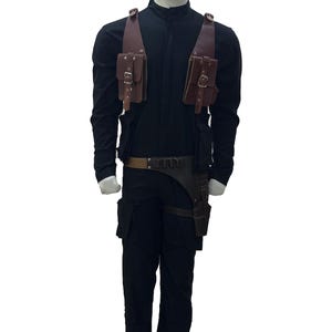 May include: Black jumpsuit with brown leather pouches and a belt. The costume includes a holster and a utility belt. The mannequin is wearing a long-sleeved black shirt and black pants. The pouches have buckles.