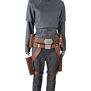 May include: A dark grey costume featuring a mock neck top, long sleeves, and matching trousers. The costume includes a brown leather belt with a silver buckle and brown leather holsters. Ideal for cosplay or costume events.