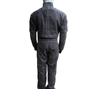 May include: A dark gray jumpsuit with white stitching and geometric patterns on the sleeves. The outfit includes a cropped jacket and matching pants. The jumpsuit is displayed on a mannequin against a white background.