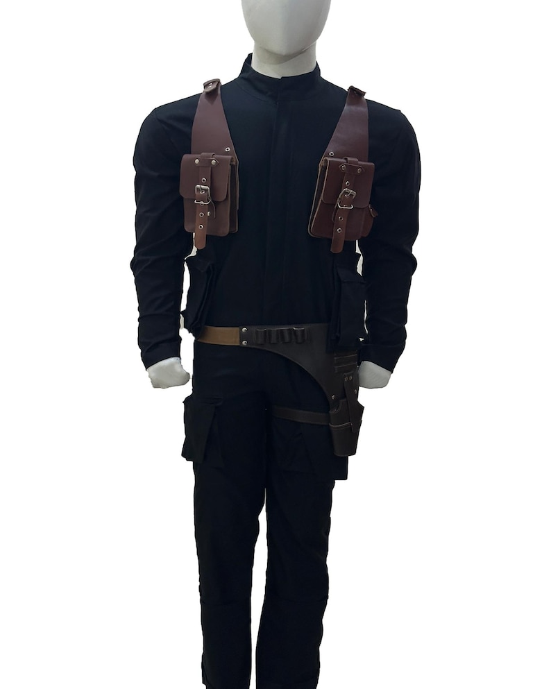 May include: Black jumpsuit with brown leather pouches and a belt. The costume includes a holster and shoulder straps with pouches. The mannequin is wearing a black long-sleeve shirt and pants.