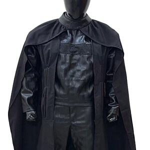 May include: A black hooded robe with a long cape. The robe has a high collar and a zipper closure. The fabric is smooth and has a slight sheen.