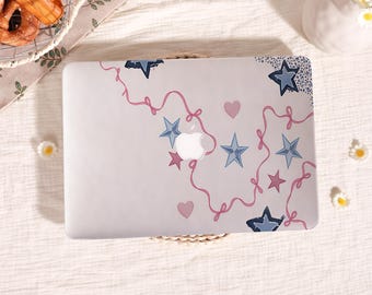 May include: A laptop cover featuring a white background decorated with a pattern of blue stars, pink stars, small pink hearts, and thin pink ribbon-like lines that loop across the surface, centred around a cutout for an Apple logo.